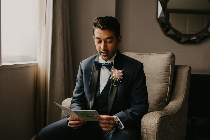 Groom reading a card from his bride before the ceremony